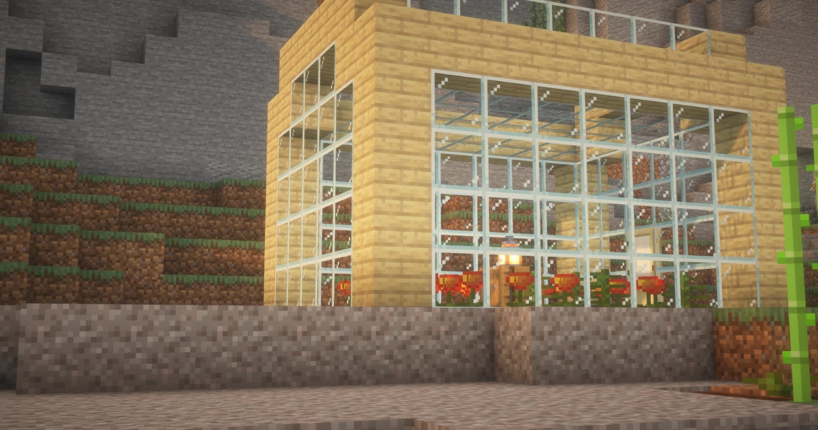 A greenhouse on the server: a sandstone frame with tall glass walls, tulips and a lantern inside, built into a terraced hillside.
